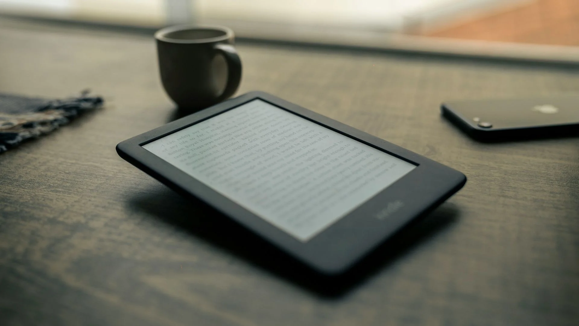 Ein E-Reader liegt auf einem Tisch.