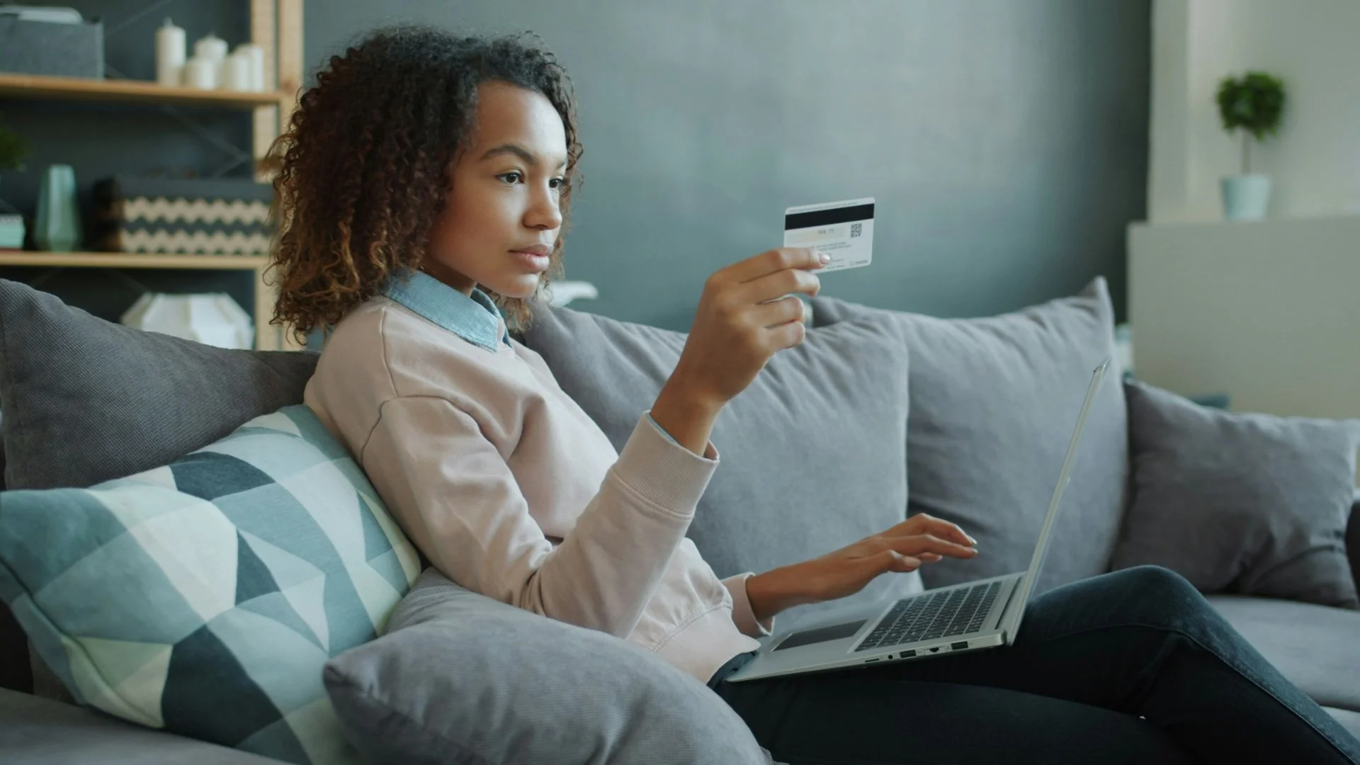 Eine Frau kauft am Laptop ein digitales Produkt per Kreditkarte.