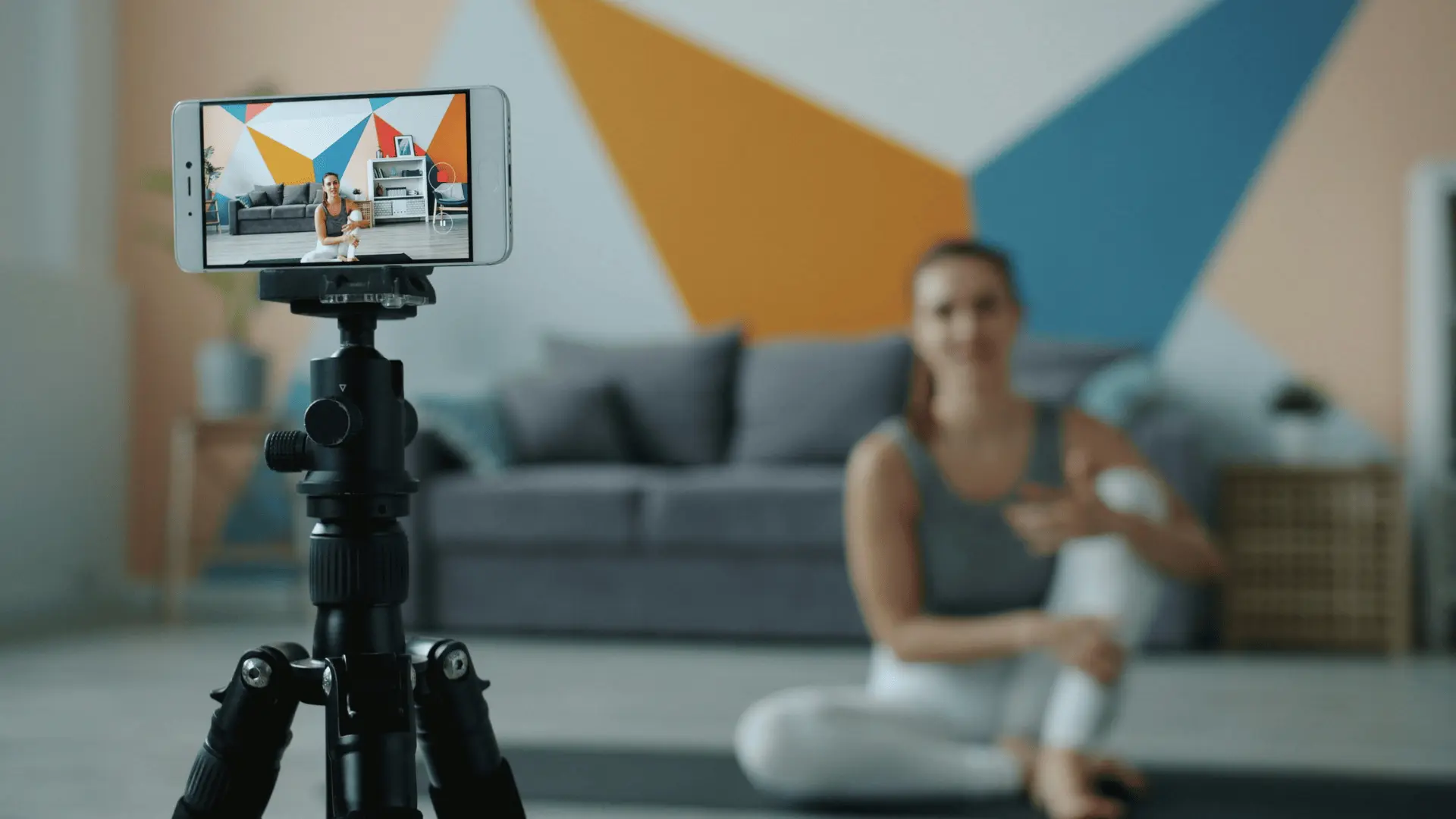 Eine Yoga-Lehrerin nimmt einem Online-Kurs mit einem Smartphone auf.